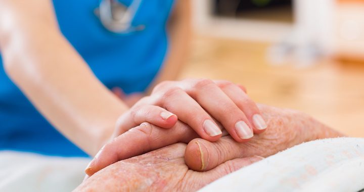 nurse holding a patients hand - national nurses week mercy health