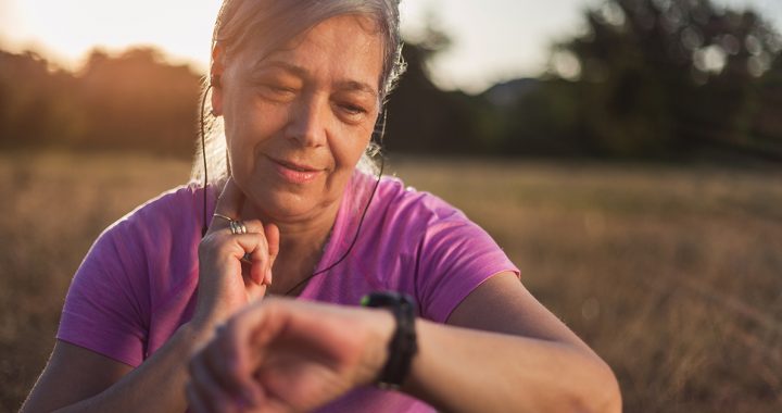 A woman checking her pulse while on a walk.