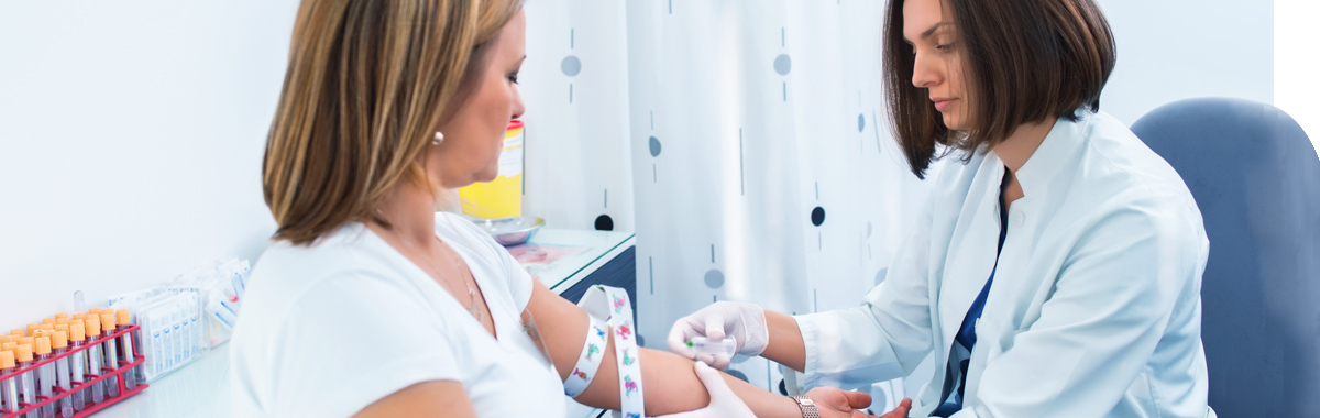 One woman taking blood from another for a fasting blood glucose test