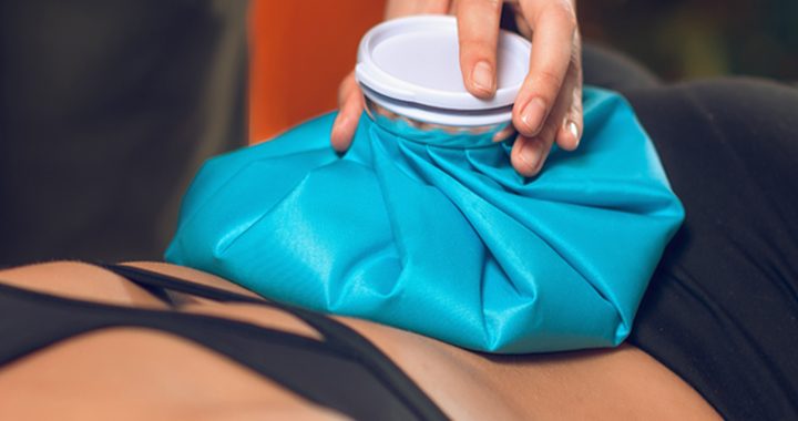 Provider placing bright blue ice bag on a woman's back for back pain