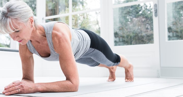 Woman in workout gear doing a plank for muscle activation