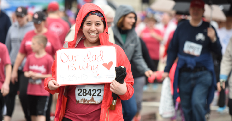 participant of Heart Mini race holding up a sign