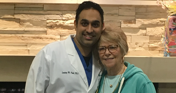 Nancy Paul stands smiling next to Dr. Sandeep Patel who performed her TMVR surgery