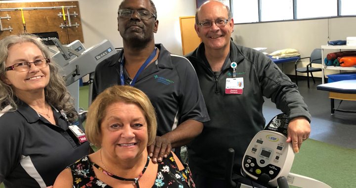 Deb Rogers, a Mercy Health Physical Therapy patient, sits in front of the orthopedic team members who helped her walk again