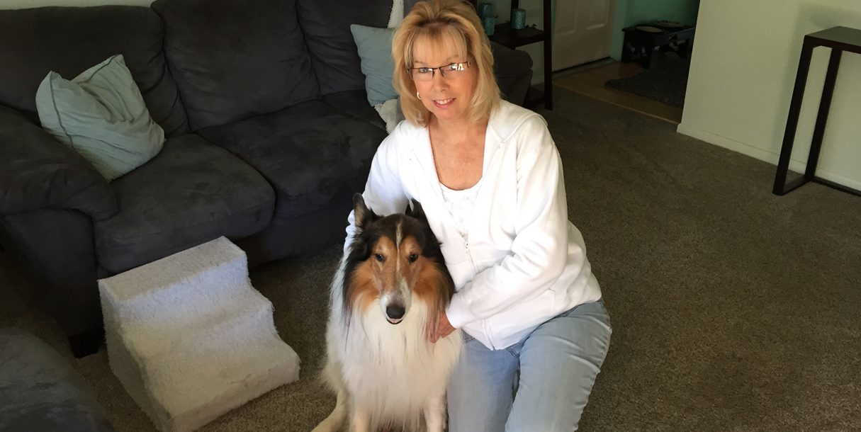 Rebecca, a trigeminal neuralgia patient, poses with her brown and white dog