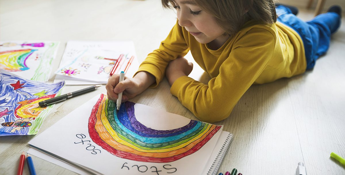 Child coloring a rainbow picture to help spread messages of hope during COVID-19.