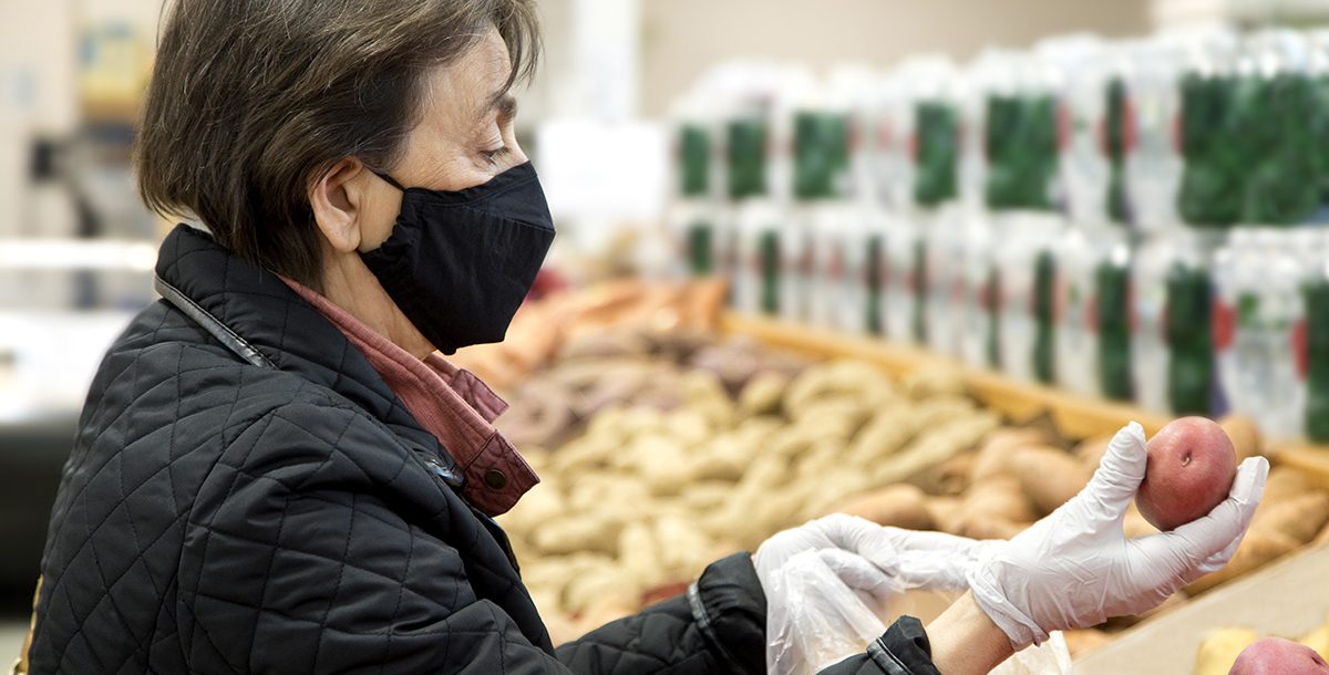 A woman at the grocery store wearing latex gloves during COVID-19.