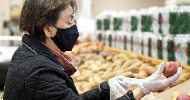 A woman at the grocery store wearing latex gloves during COVID-19.