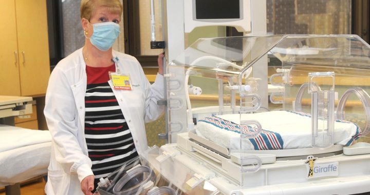 Debbie Pollander, RN, standing next to the infant care station.
