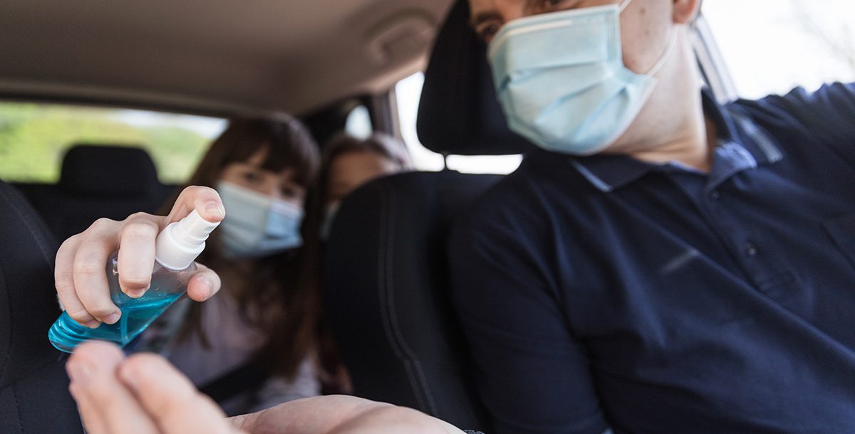 A family putting hand sanitizer on in their car during COVID-19.
