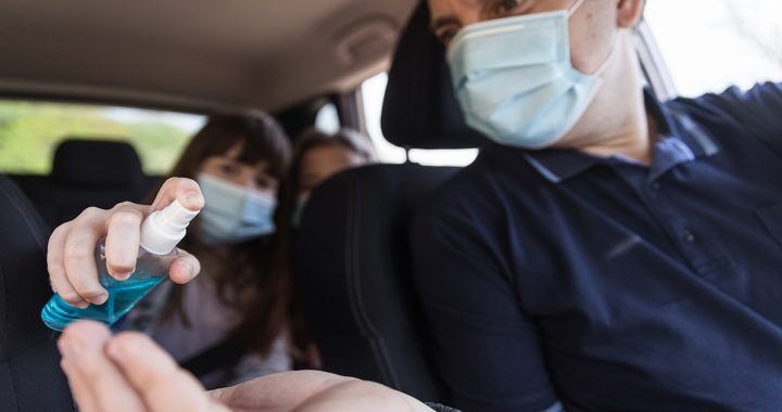 A family putting hand sanitizer on in their car during COVID-19.