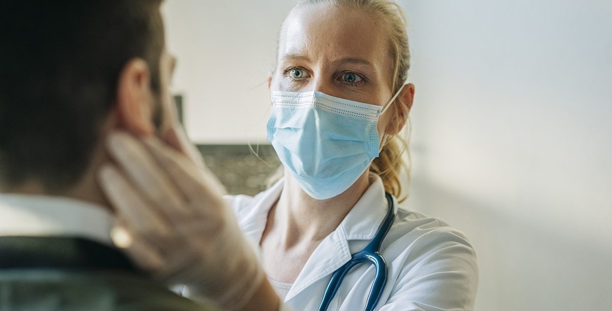 A medical provider taking care of a patient with a face mask on.