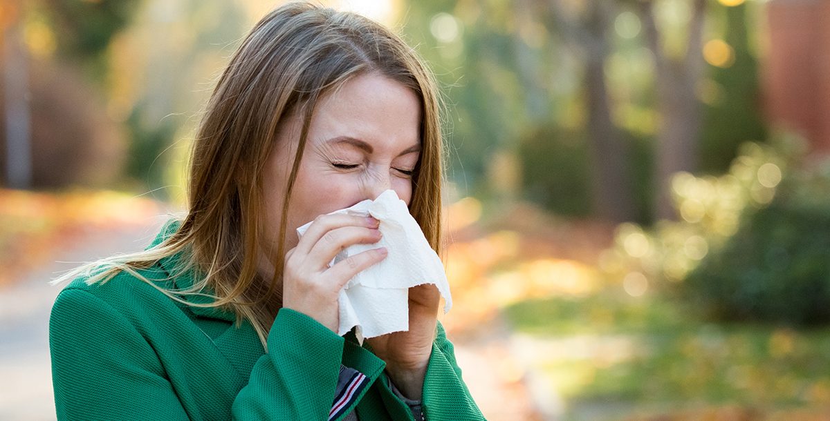 A woman sneezing during COVID-19