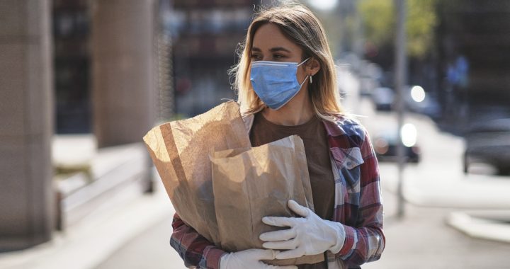 A woman shopping with a face mask on during the summer.