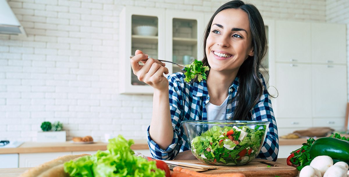 A woman enjoying a salad as part of her plant-based diet.