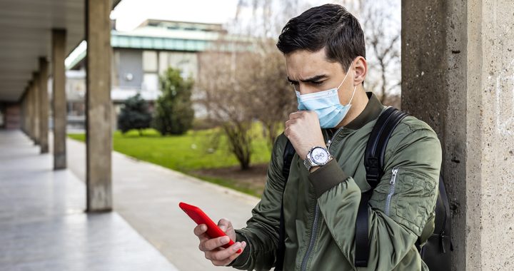 A man getting a contact tracing alert on his smartphone.