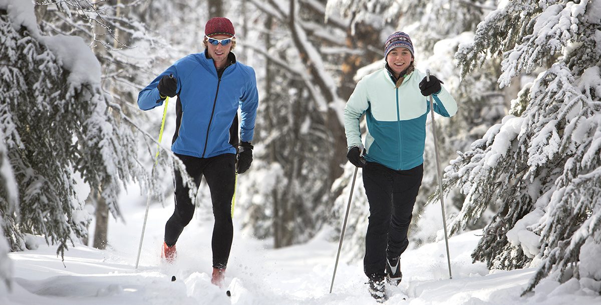 Two people cross country skiing.