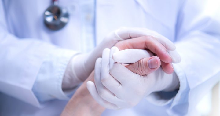 A health care provider holding a patient's hand.