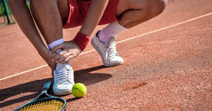 A person experiencing an ankle injury while playing tennis.