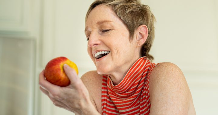 A woman eating an apple.