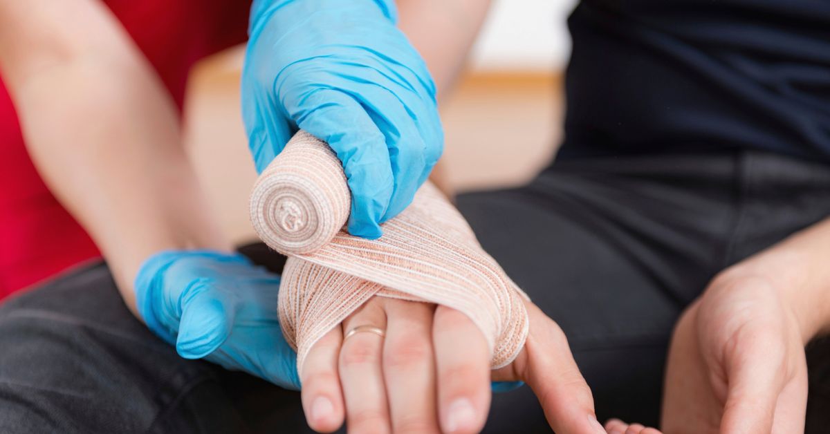 An emergency care professional wraps a patient's hand as part of proper snake bite treatment.